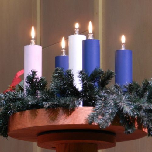 Five candles surrounded by a green Advent wreath